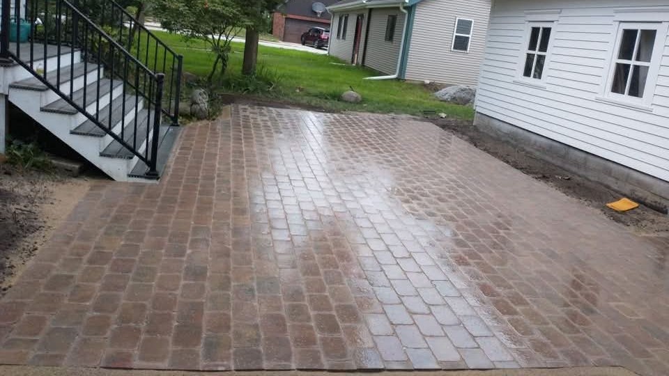 New paver patio at the foot of a set of steps